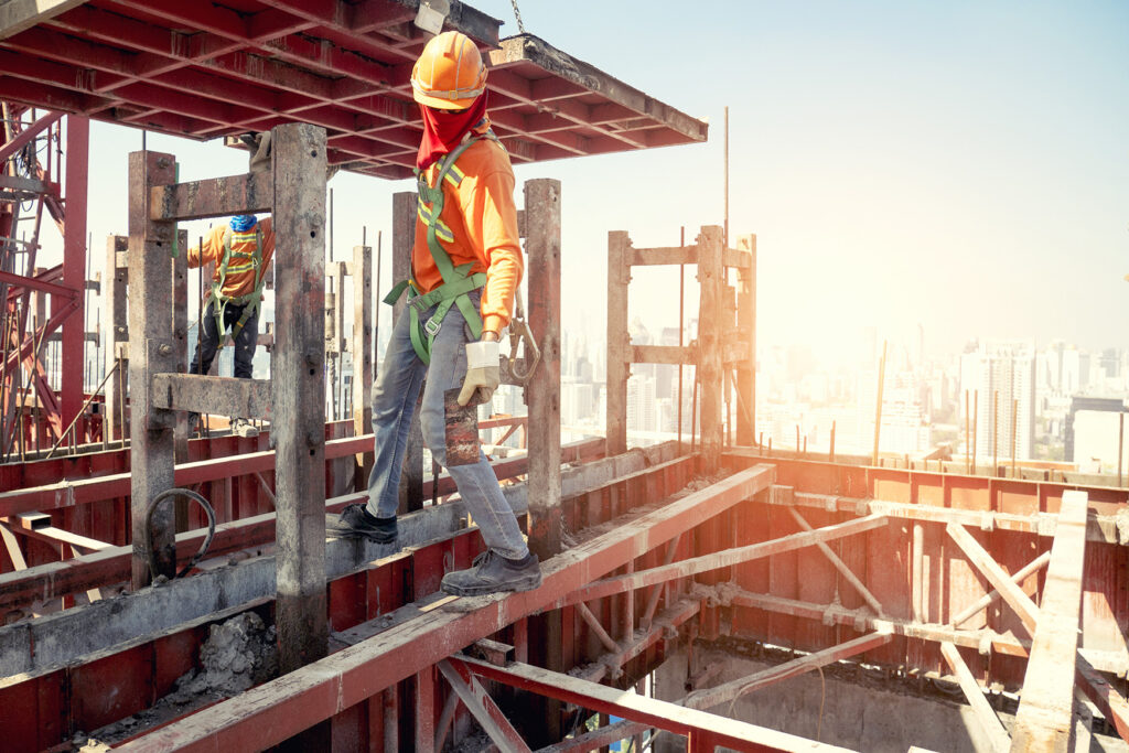 A construction worker standing on top of a metal structure. Construction accident lawyers can help you if you’ve been injured in a construction accident. 