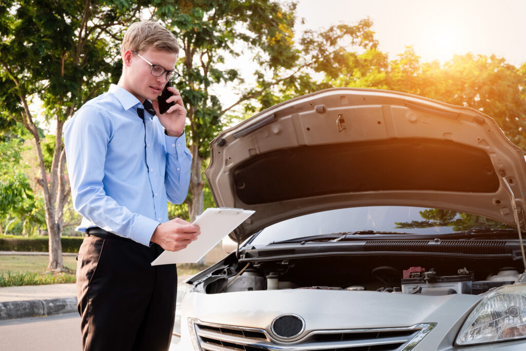 Insurance adjuster talking on phone and looking at clipboard in front of car accident. If you’ve been involved in a car crash, an insurance claims lawyer can help you get the maximum amount for your claim.