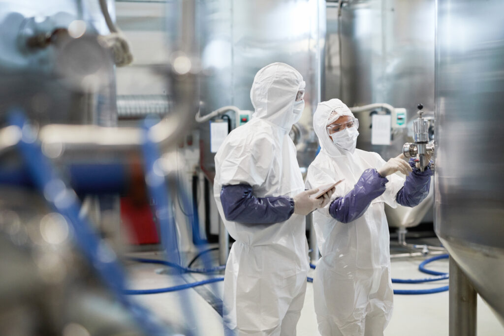 Two plant workers in protective suits. Our plant & refinery accident attorneys will fight for you if you’ve been injured while working. 