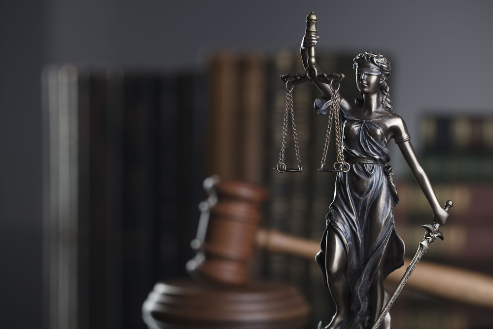 Lady Justice holding scales and sword, symbolizing the enforcement of forum-selection clauses in Texas law.