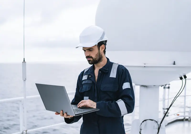 An offshore worker standing on a boat looking at computer. A maritime injury lawyer in Houston can help if you’ve recently been injured offshore.